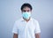 AsianÂ Man in medical maskÂ Coronavirus pandemic disease on grey background. COVID-19 virus from China epidemic outbreak to global